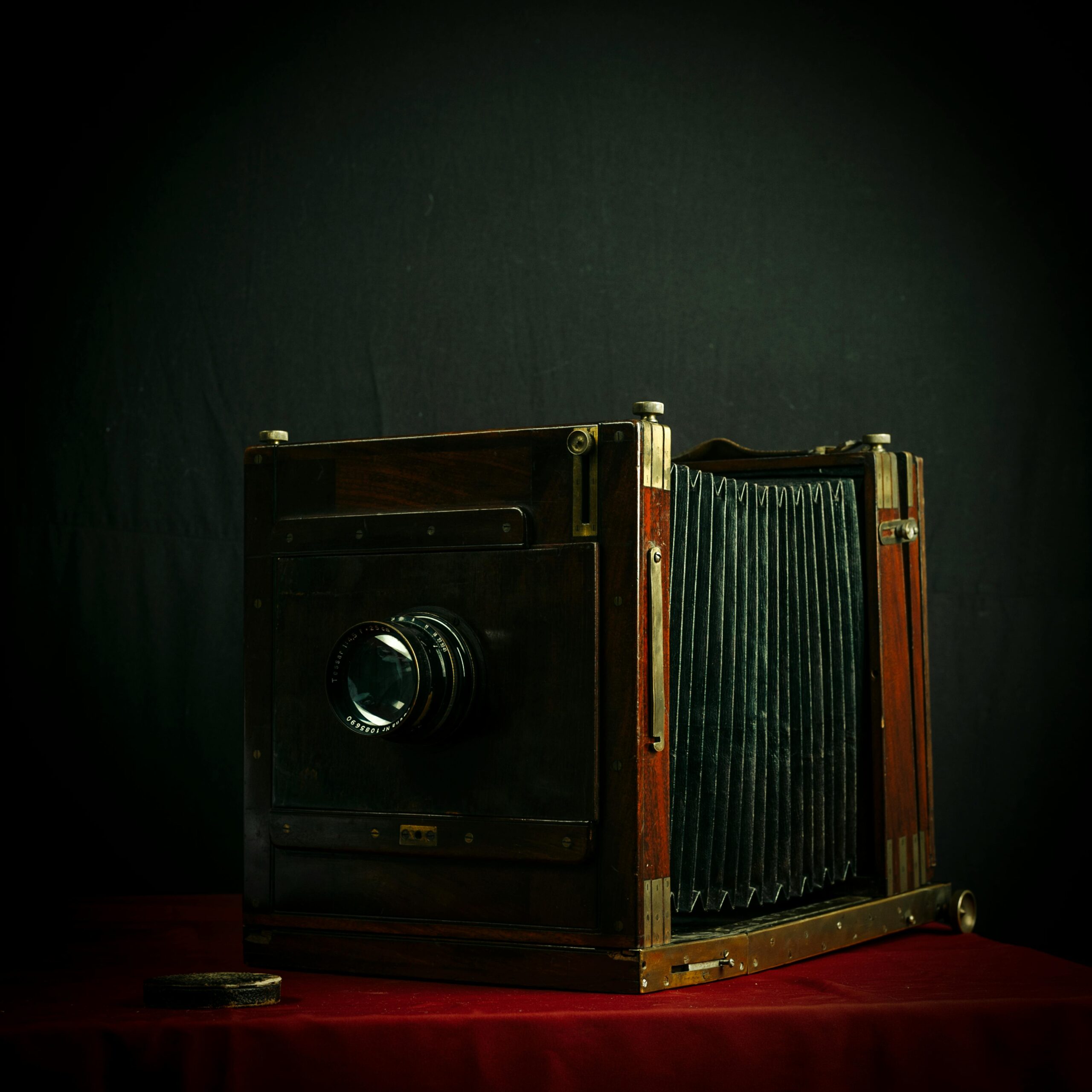 Classic wooden bellows camera displayed on red velvet, perfect for vintage and photography enthusiasts.
